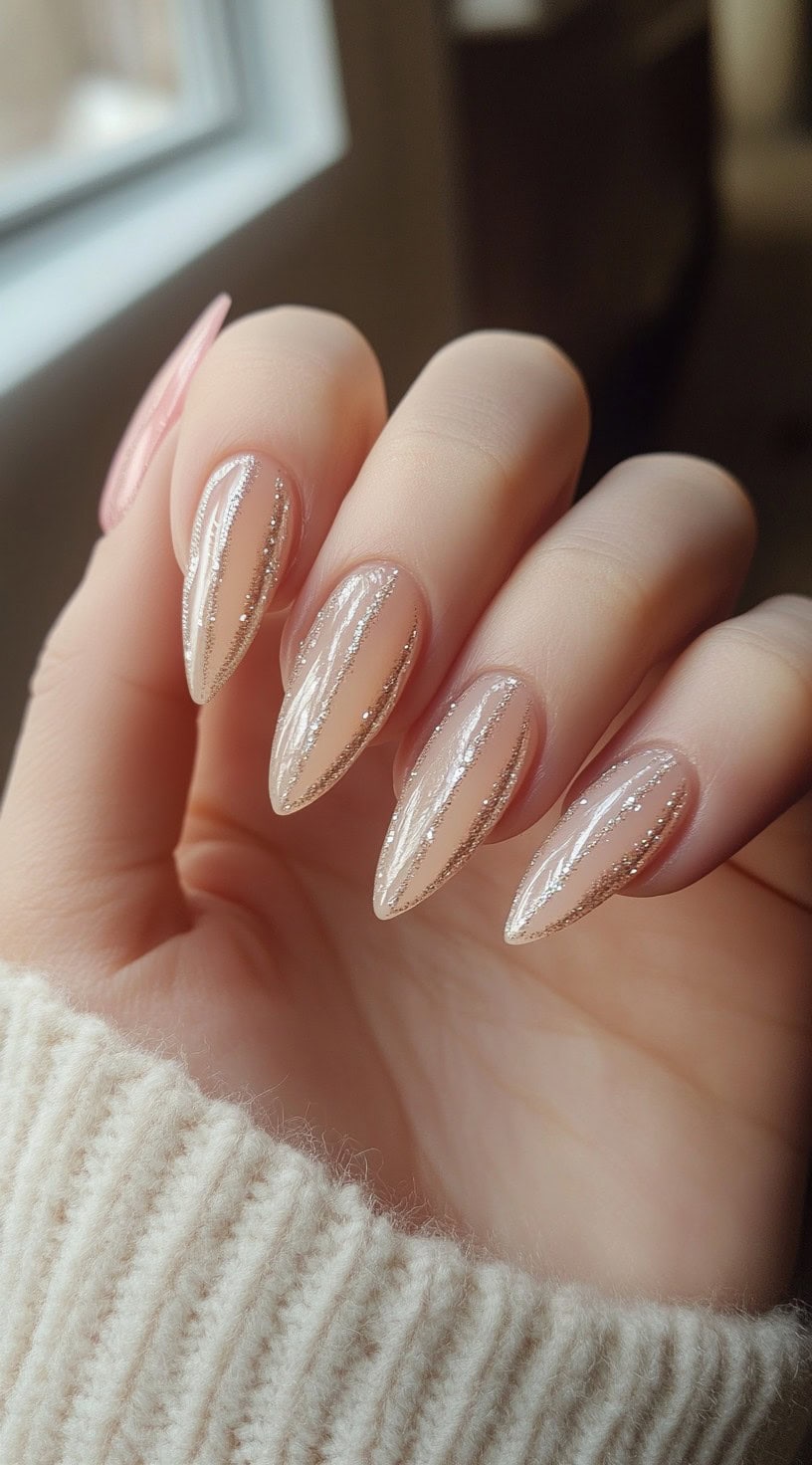 Five almond-shaped nude nails featuring vertical glitter stripes that taper to a point.