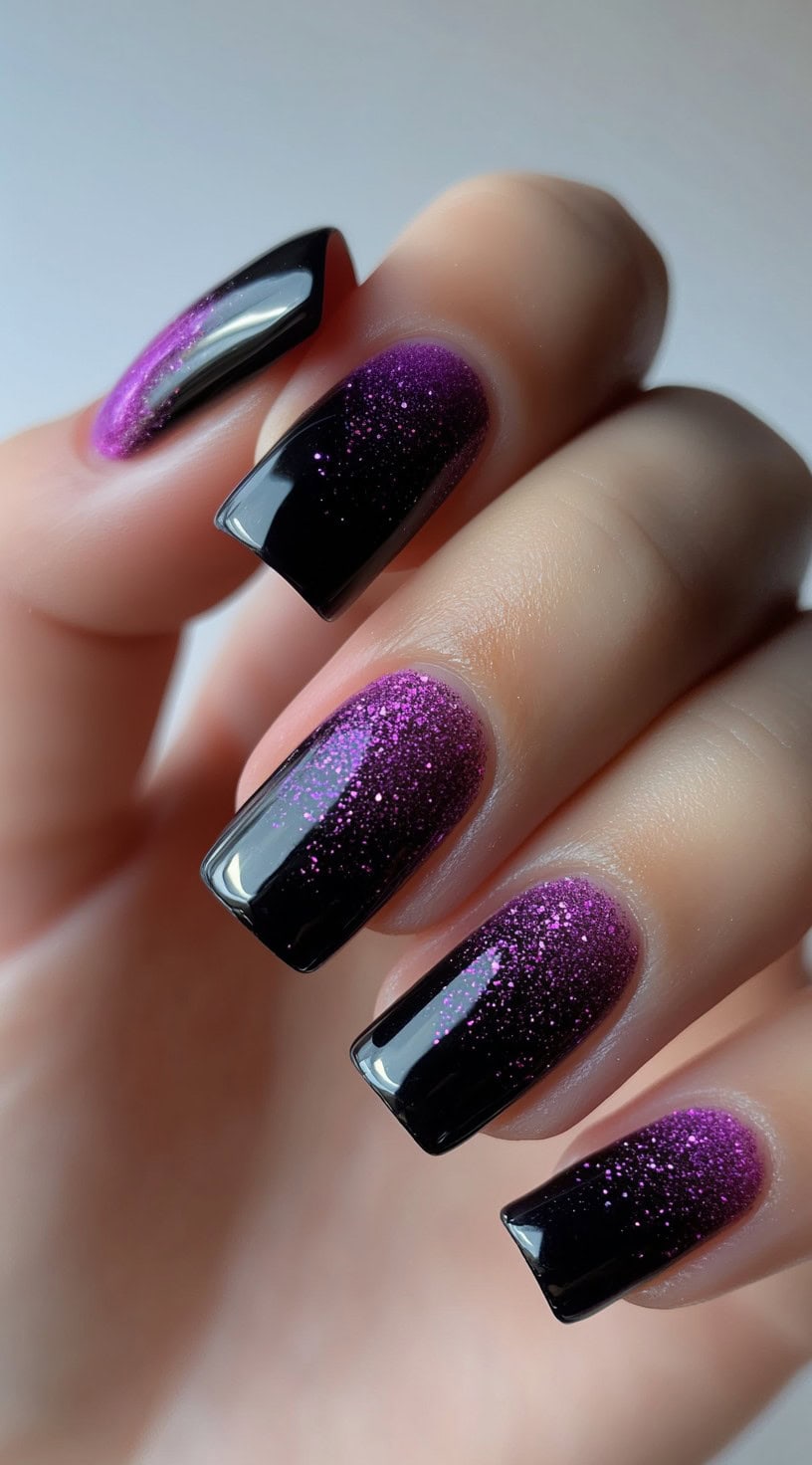 Square-shaped nails with a black base and sparkly purple ombré glitter fade.