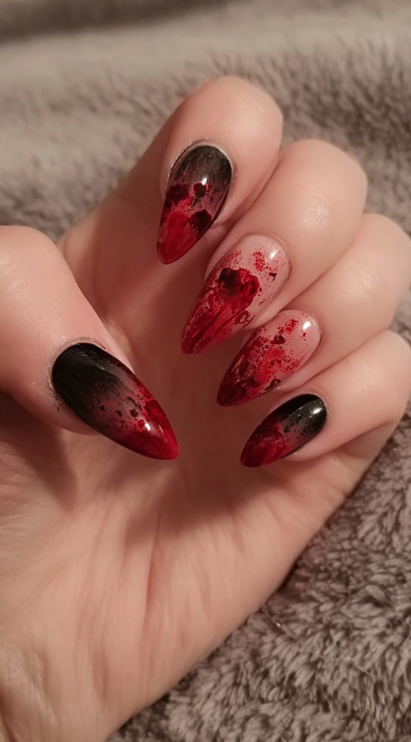 Medium almond nails with a nude base splattered in dripping blood-red and black polish.