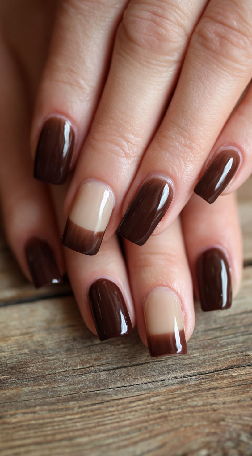Square nails with a clear base and chocolate brown French tips, alternating with full chocolate brown nails.
