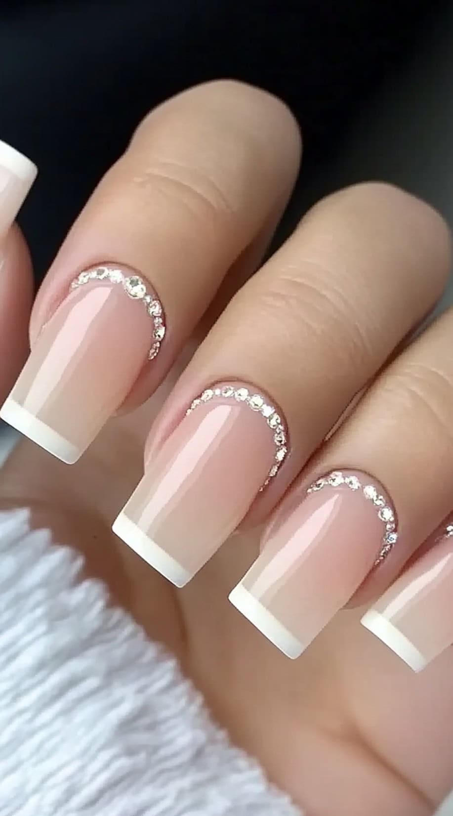 Square French tip nails with delicate rhinestone arcs along the cuticles.