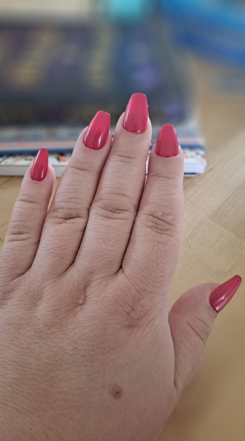 Medium-length coffin-shaped nails in a vibrant hot pink gloss that enhance the fingers with a clean, bold finish.