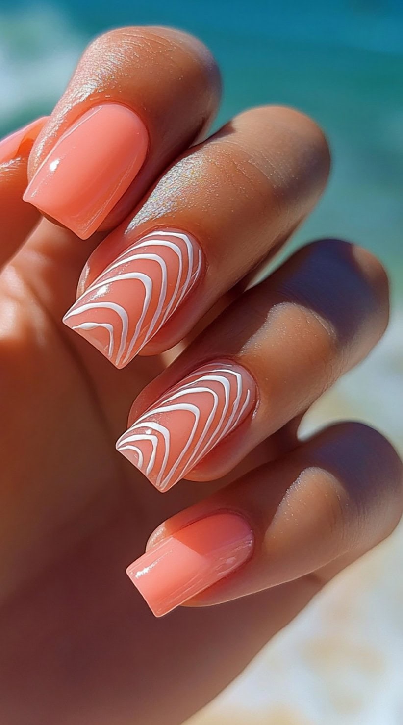 Bright coral square nails featuring a swirling white wave design on two accent nails.