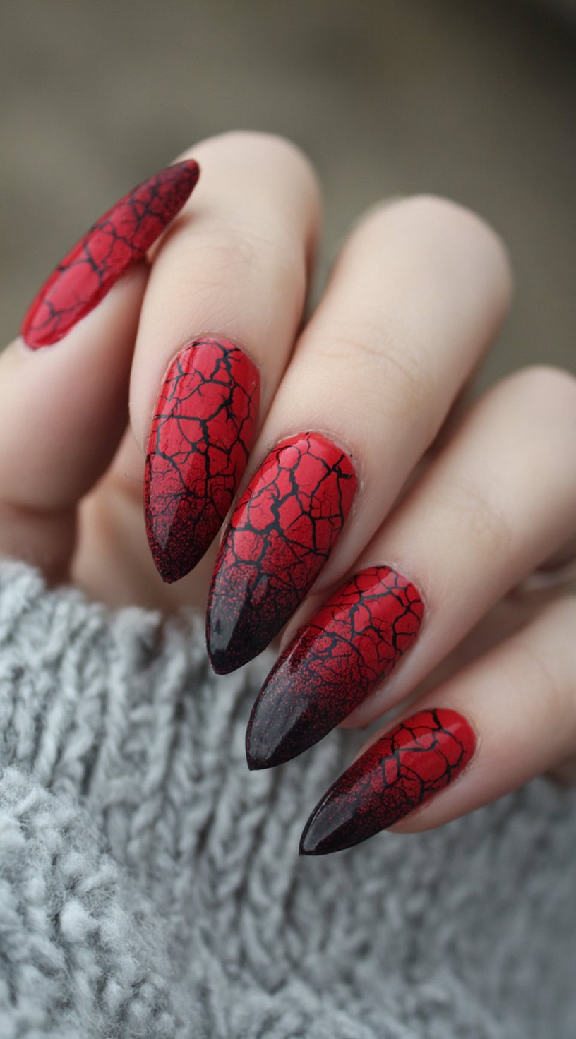 A hand with stiletto nails in a red and black gradient with a cracked vein pattern resembling lava or dried blood.