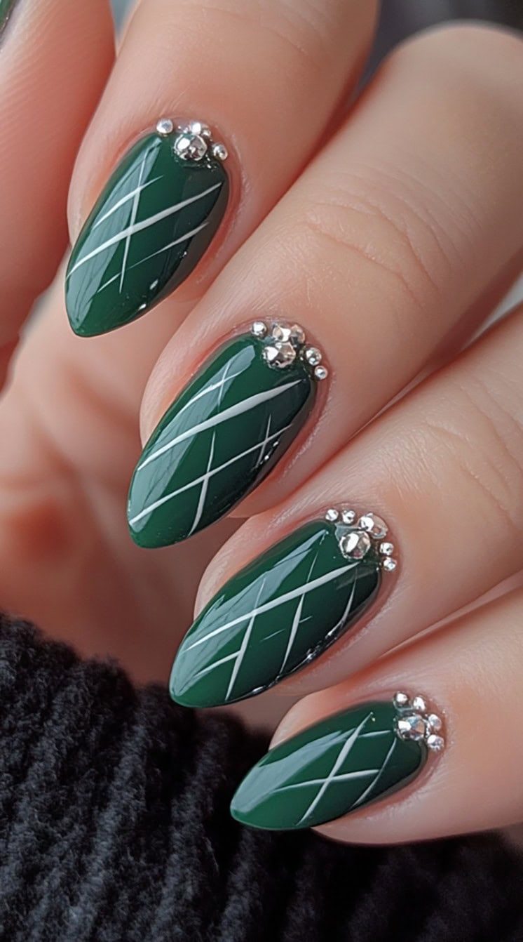 Deep forest green almond-shaped nails with white plaid lines and rhinestone details at the cuticle.