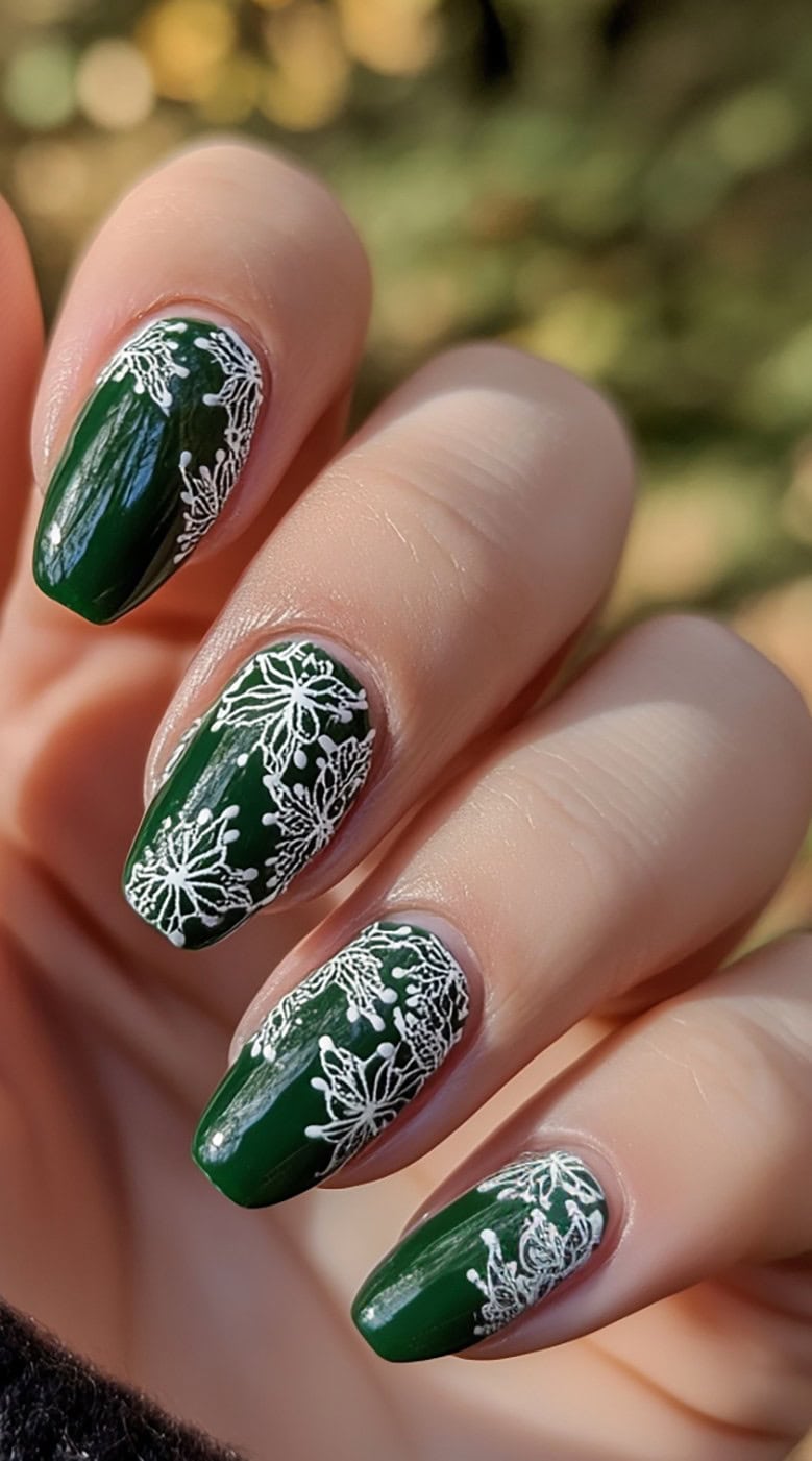 Dark green glossy nails with delicate white floral stamping near the tips.