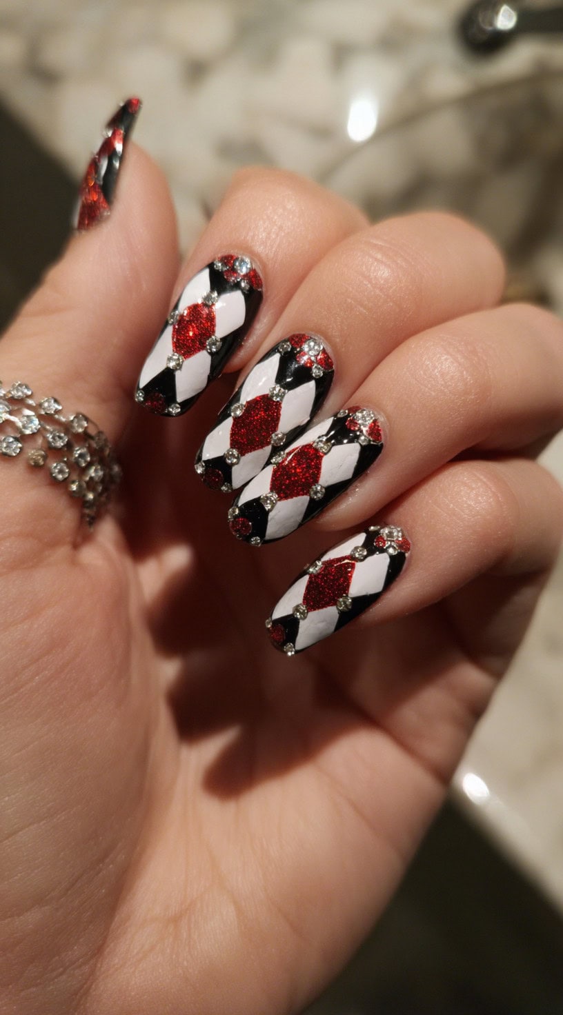 Long almond-shaped nails with red glitter diamonds, black and white checkered harlequin pattern, and rhinestone accents.