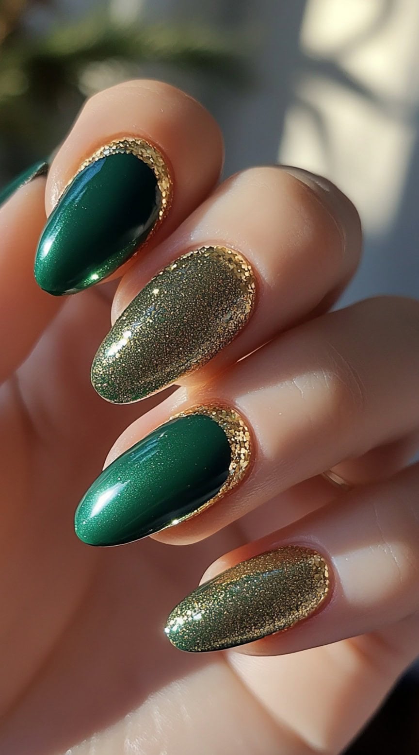 A set of almond-shaped nails featuring a deep emerald green and shimmering gold, framed with a glittering gold border for a regal touch.