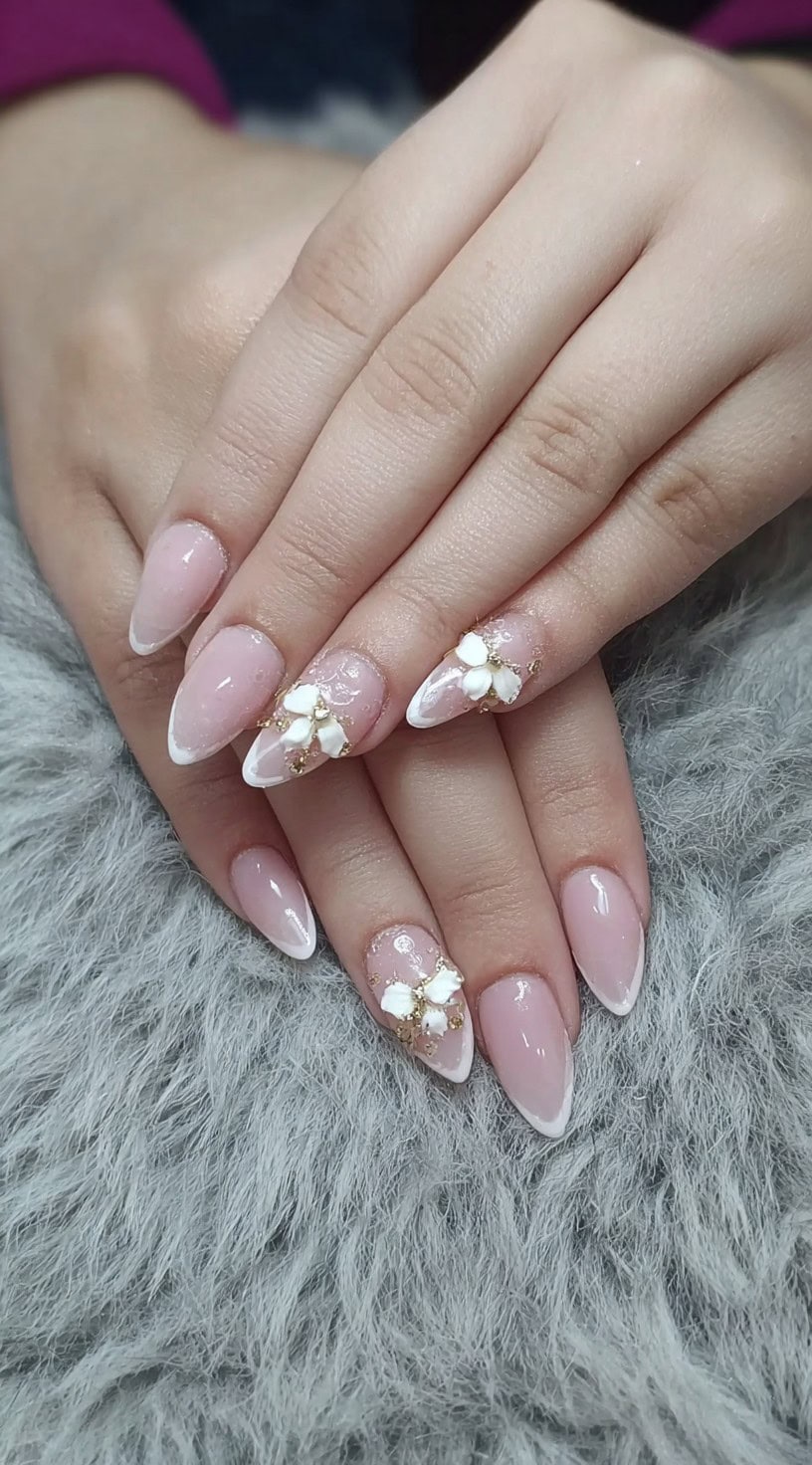 Classic French manicure with a soft pink base, accented by 3D white flowers and gold micro-beads on a few nails.
