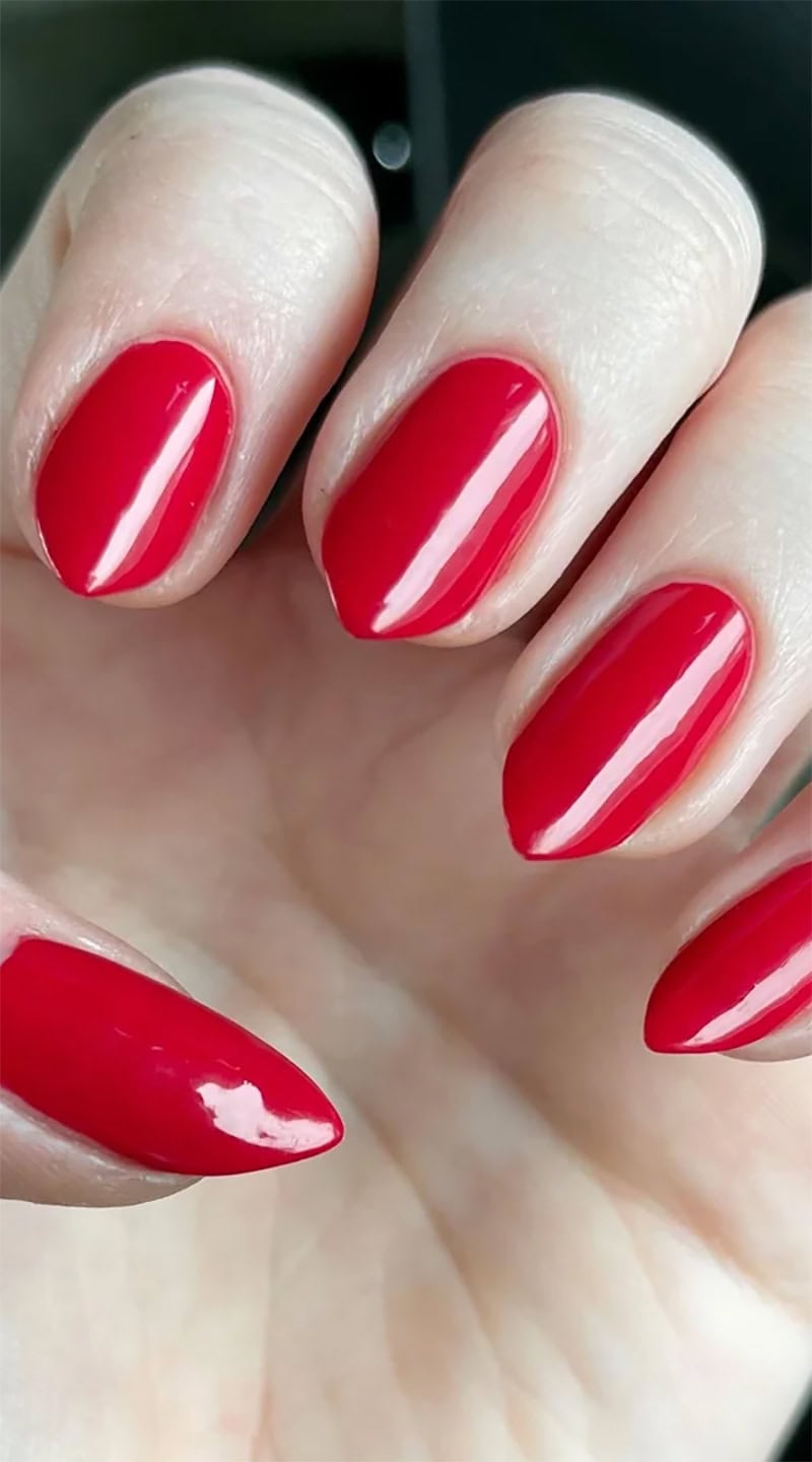 Freshly painted red nails with a glossy finish and no signs of chipping on pale skin.
