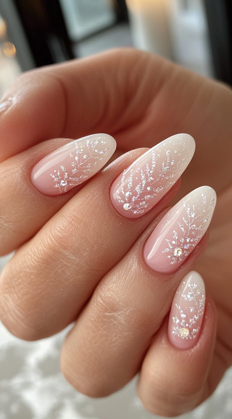 Almond-shaped nails with a soft pink-to-white ombré base, featuring delicate silver branch-like accents and tiny crystal embellishments.