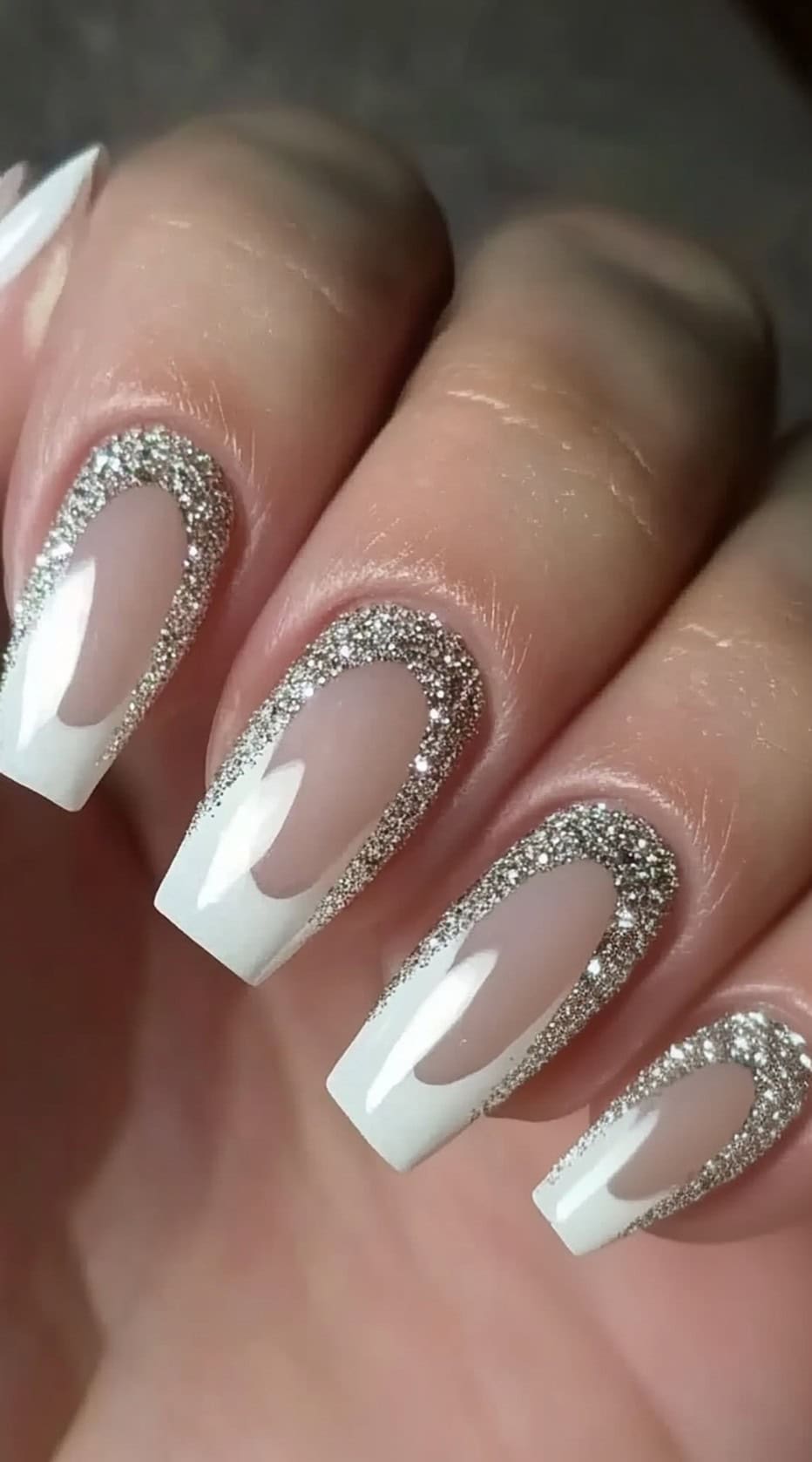 Square-shaped nails with a sheer pink base, white tips, and a sparkling silver glitter outline.