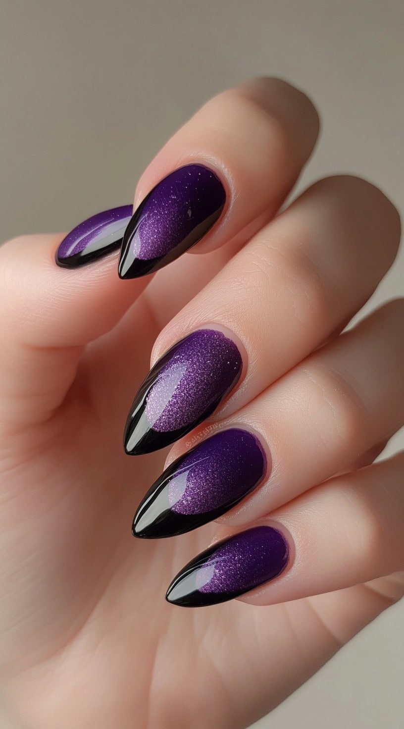 Almond-shaped nails with a sparkly purple base and glossy black French tip accents.