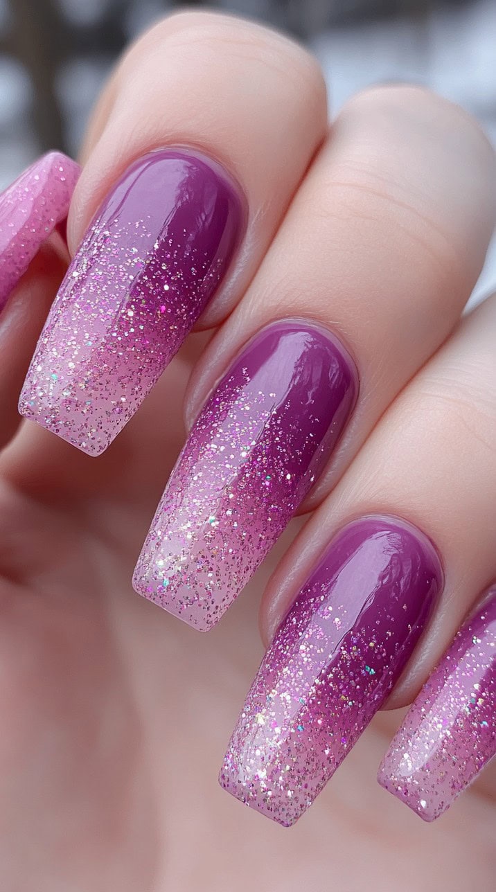 Long square-shaped nails with a pink-to-purple ombre base and layered fine glitter across the entire surface.