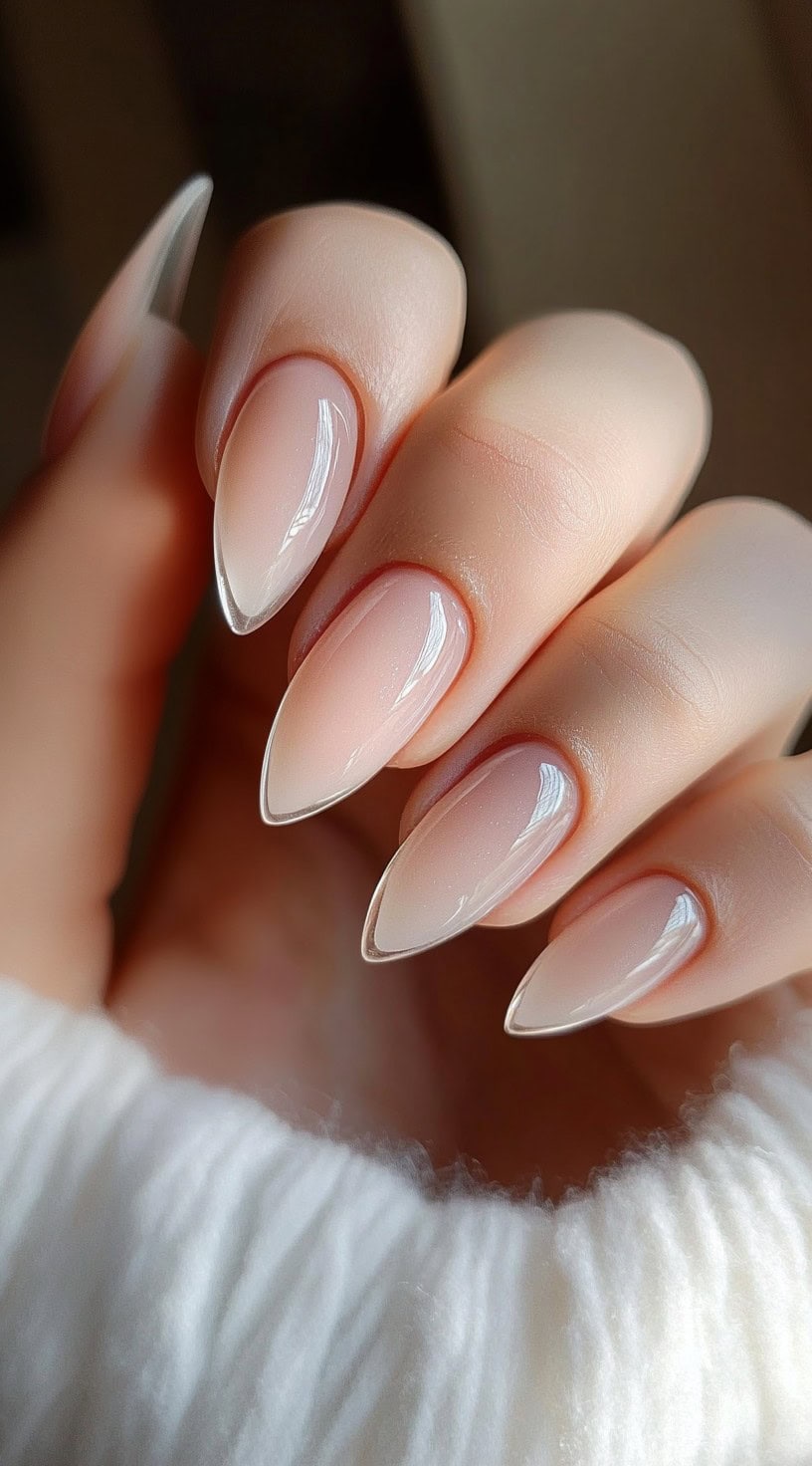 Almond-shaped nails with a sheer natural pink base and high-gloss finish for a polished, effortless look.