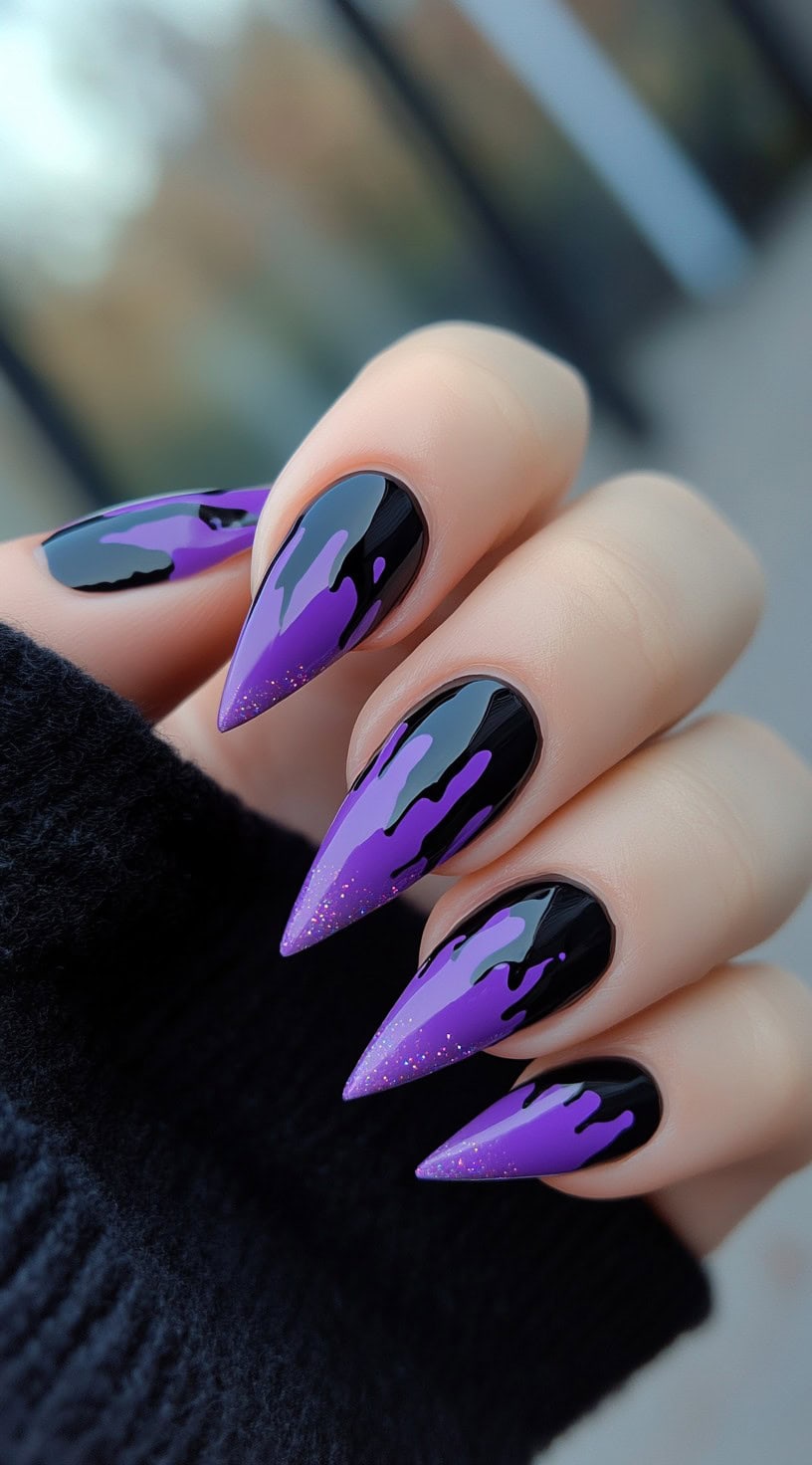 A set of long stiletto nails in black with purple drip designs flowing from the tips toward the base, some with fine shimmer.