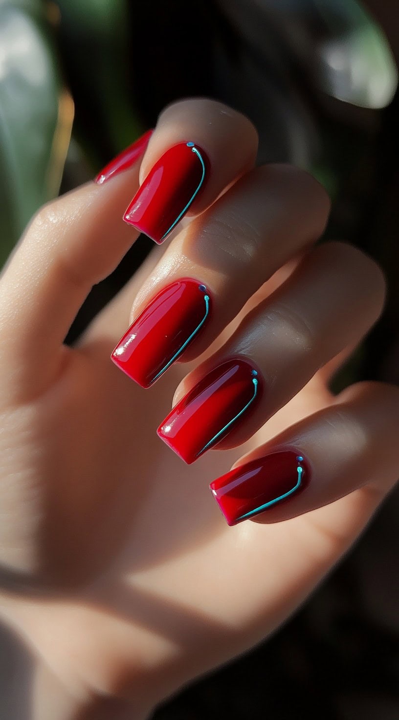 A hand with long, square-shaped nails painted in a deep glossy red, featuring a subtle neon blue outline tracing the edges.