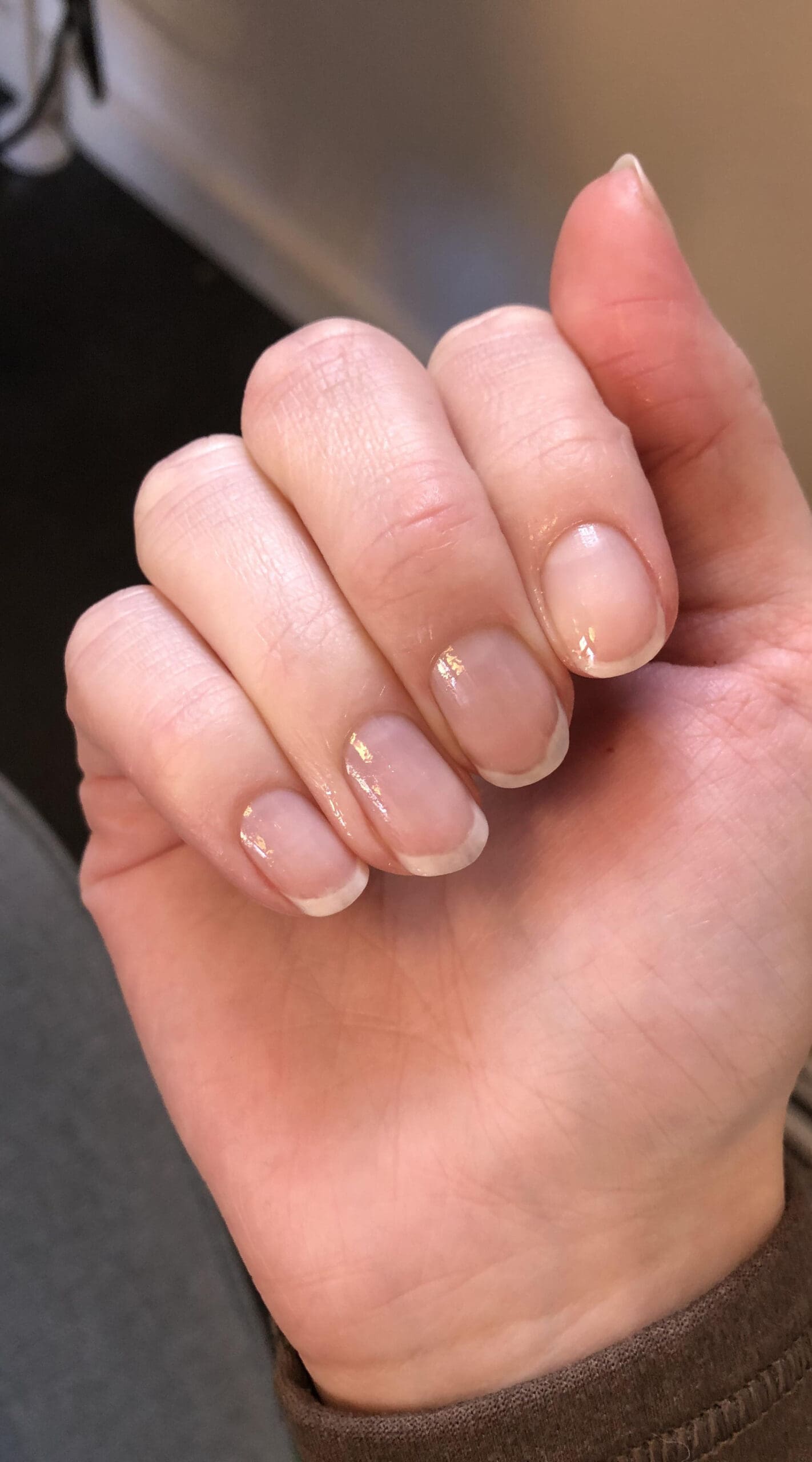 Short, clean natural nails with a subtle shine, appearing healthy and recovered after a gel break.