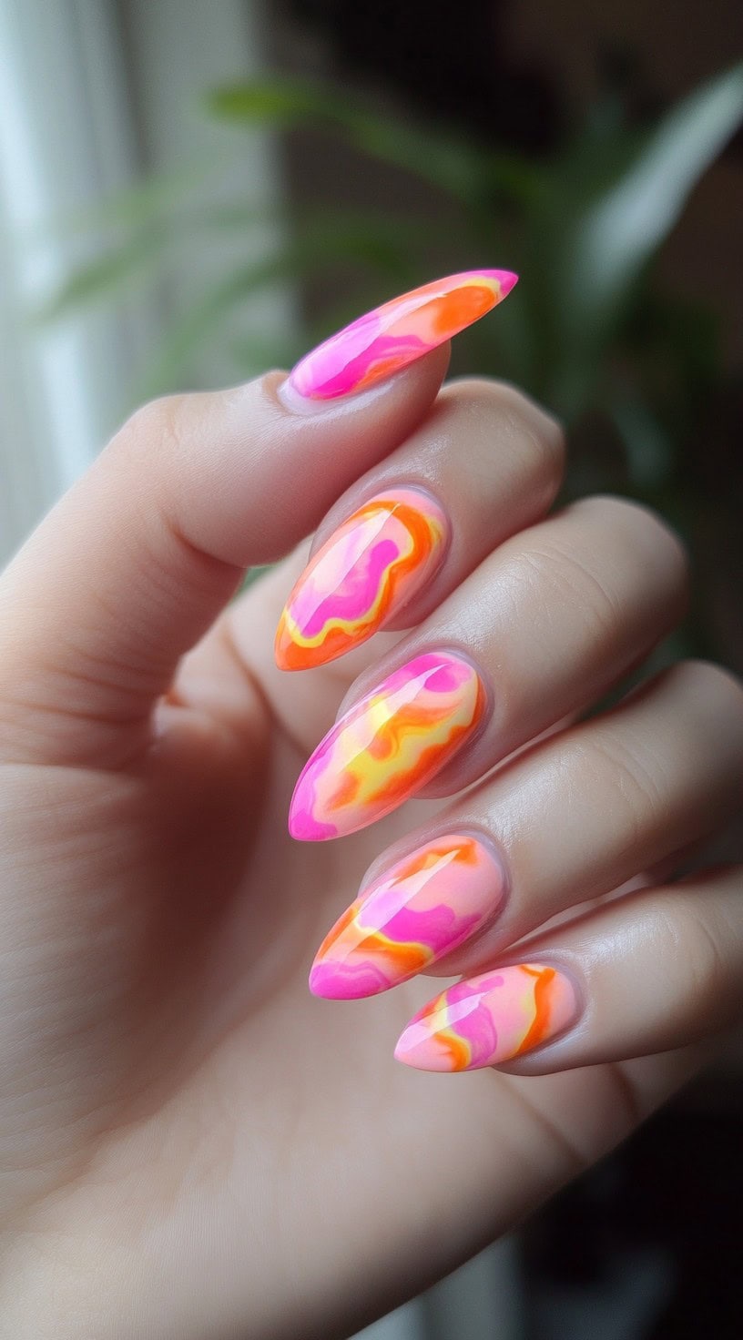 Almond nails with abstract neon swirls of pink, orange, and yellow layered across a translucent base.