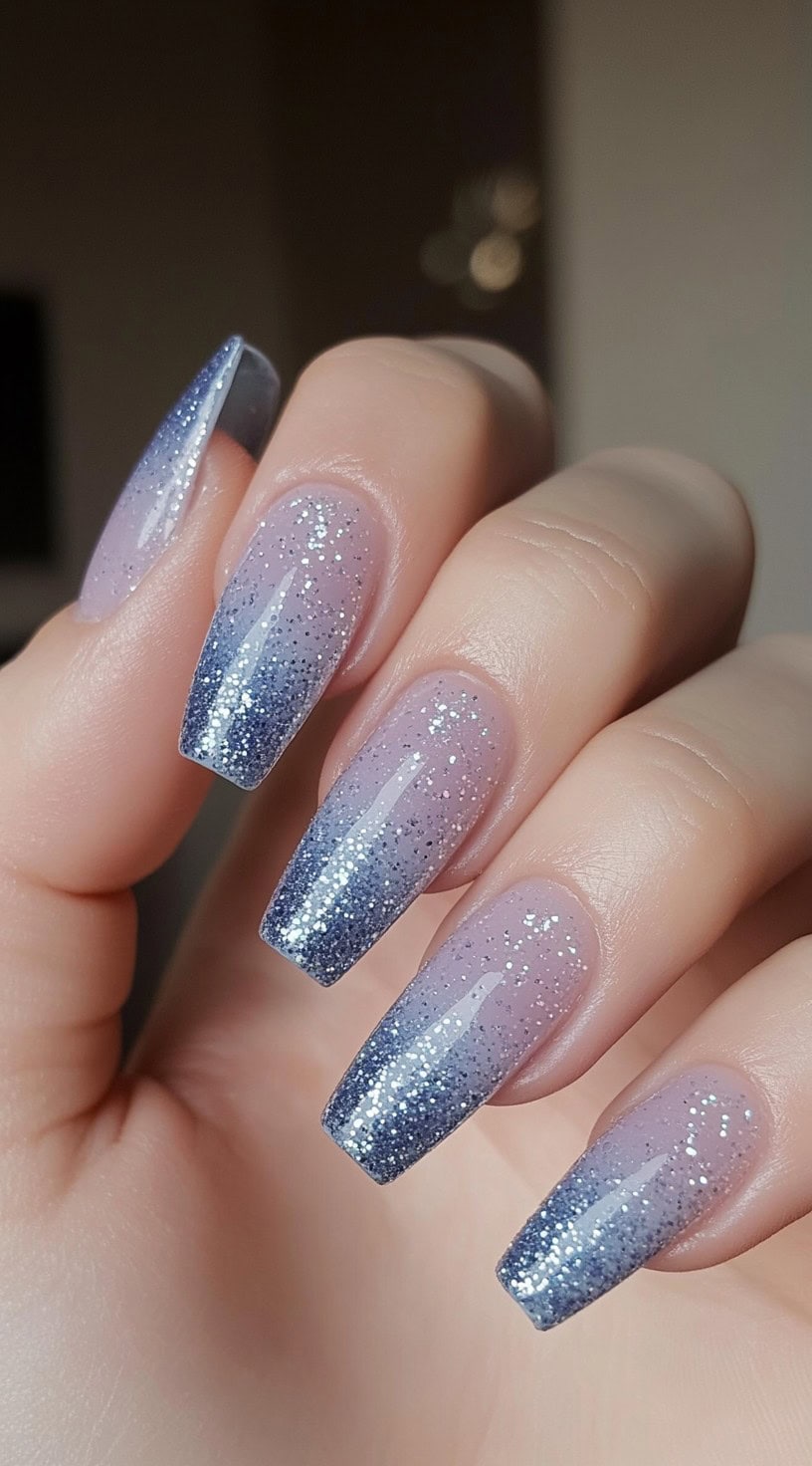 Long coffin nails with a soft lavender-to-blue ombre and silver glitter gradient over the top.