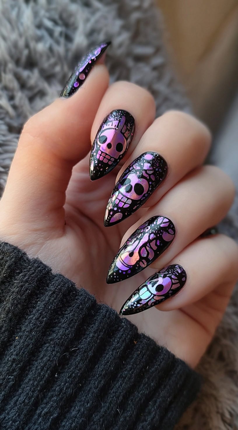 A hand with almond-shaped nails coated in black polish and decorated with shimmering holographic skulls and spooky abstract shapes.