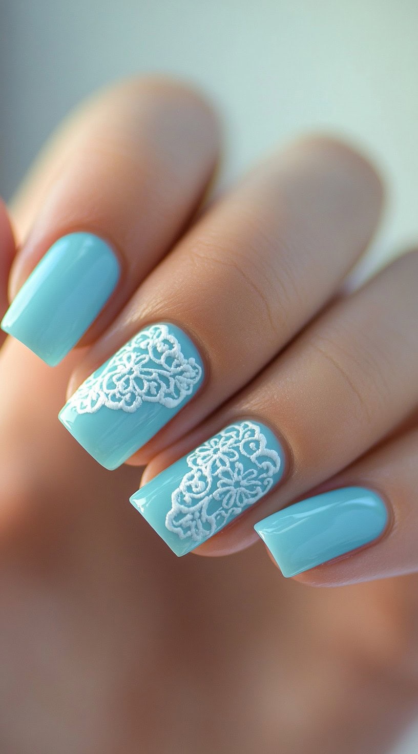 Light blue square nails with intricate white lace floral accents.