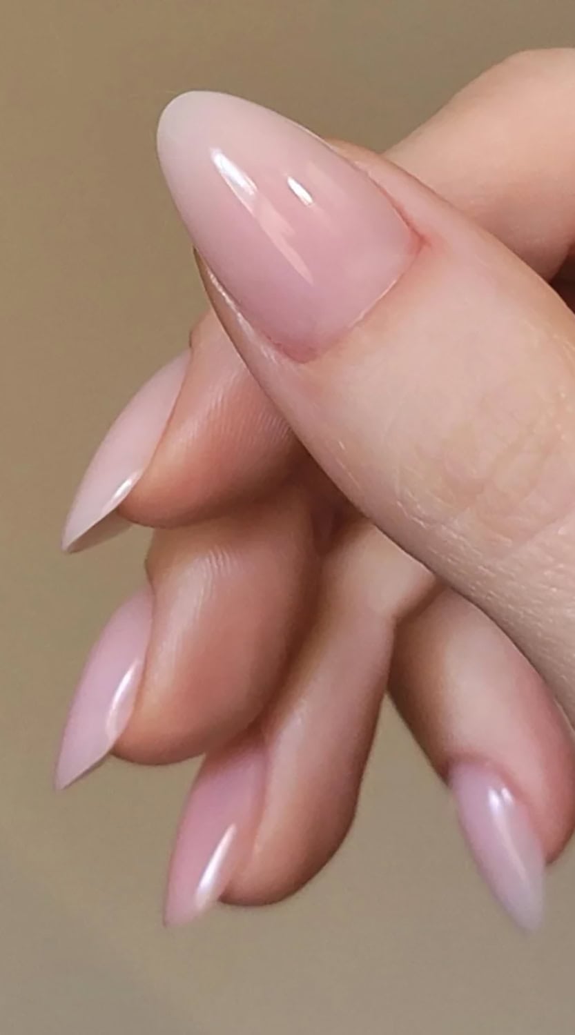 Soft pink gel nails shaped into a refined almond tip, reflecting light for a clean, elegant look.