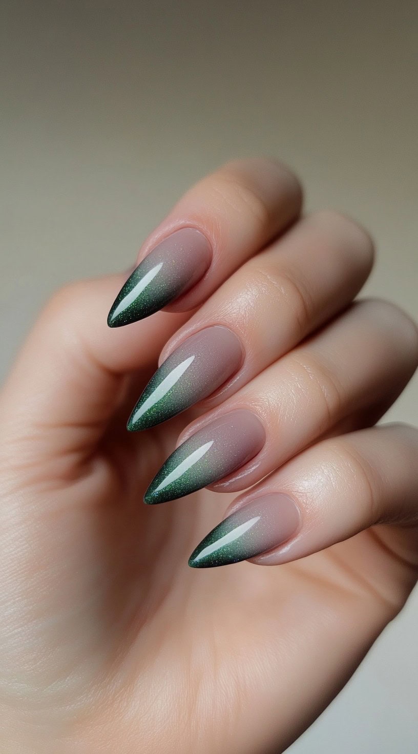 A smooth ombré gradient from soft lavender bases to deep forest green tips on almond-shaped nails with a glossy finish.