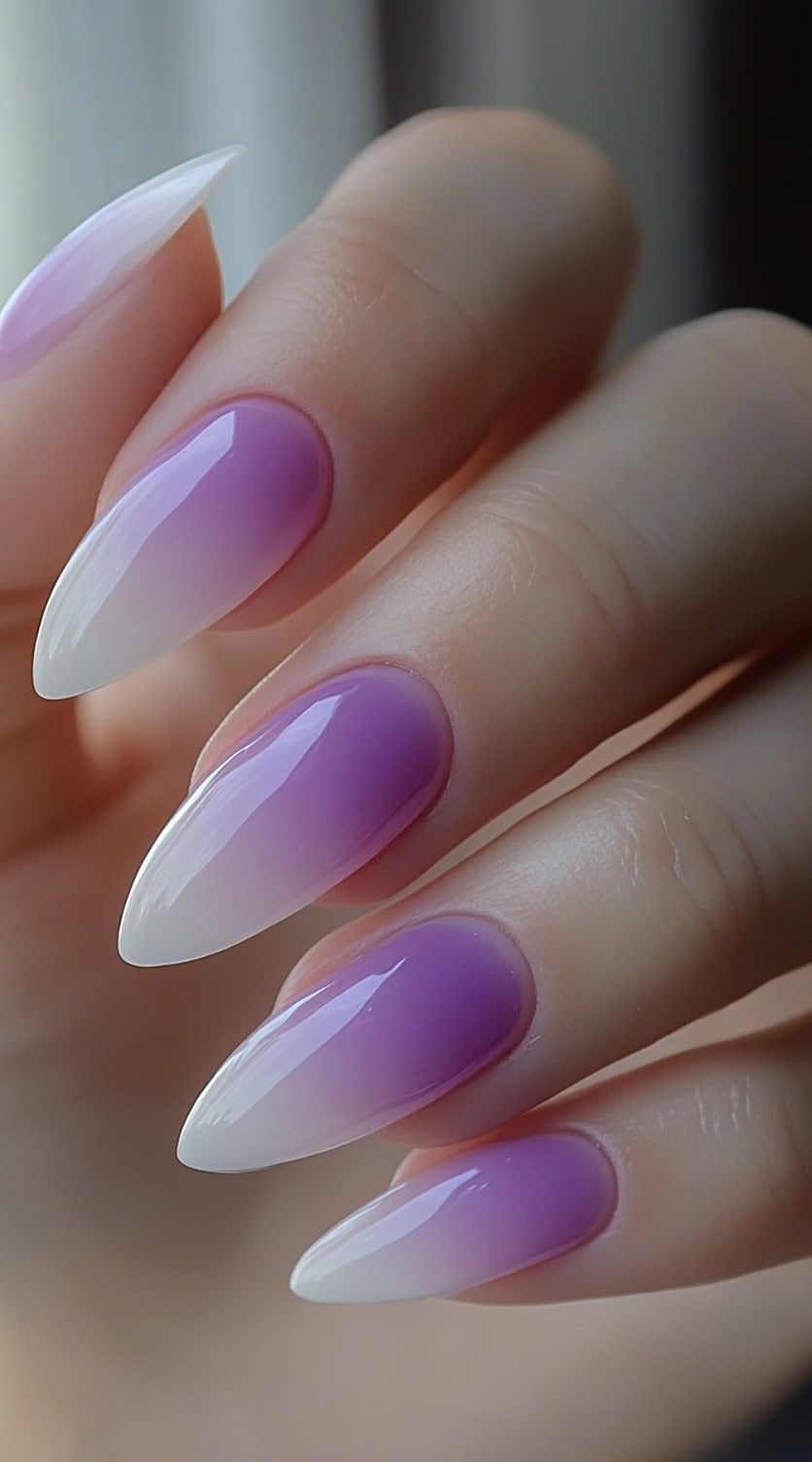 Almond-shaped nails with a seamless ombre blend from pastel lilac to bright white in a glossy finish.