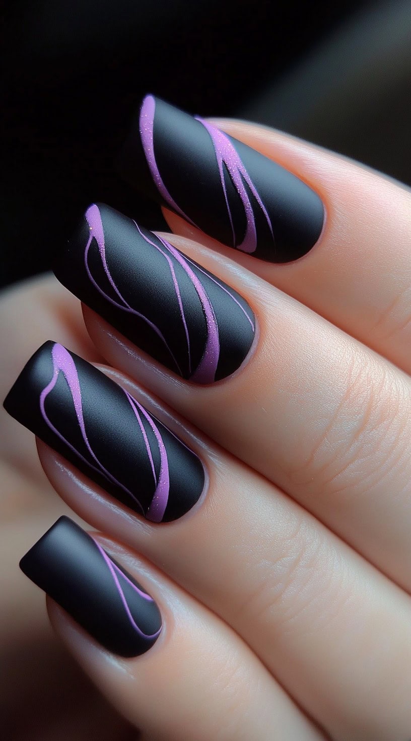 A hand with matte black square nails decorated with fine, shimmery violet swirl lines on each nail.