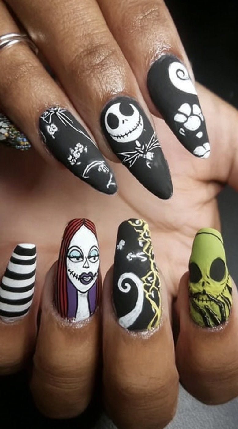 Hands with matte black nails decorated with Jack, Sally, Oogie Boogie, and striped designs.