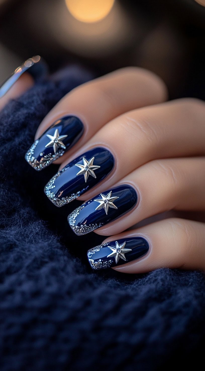 Square-shaped deep navy nails with silver glitter tips and large silver star embellishments.