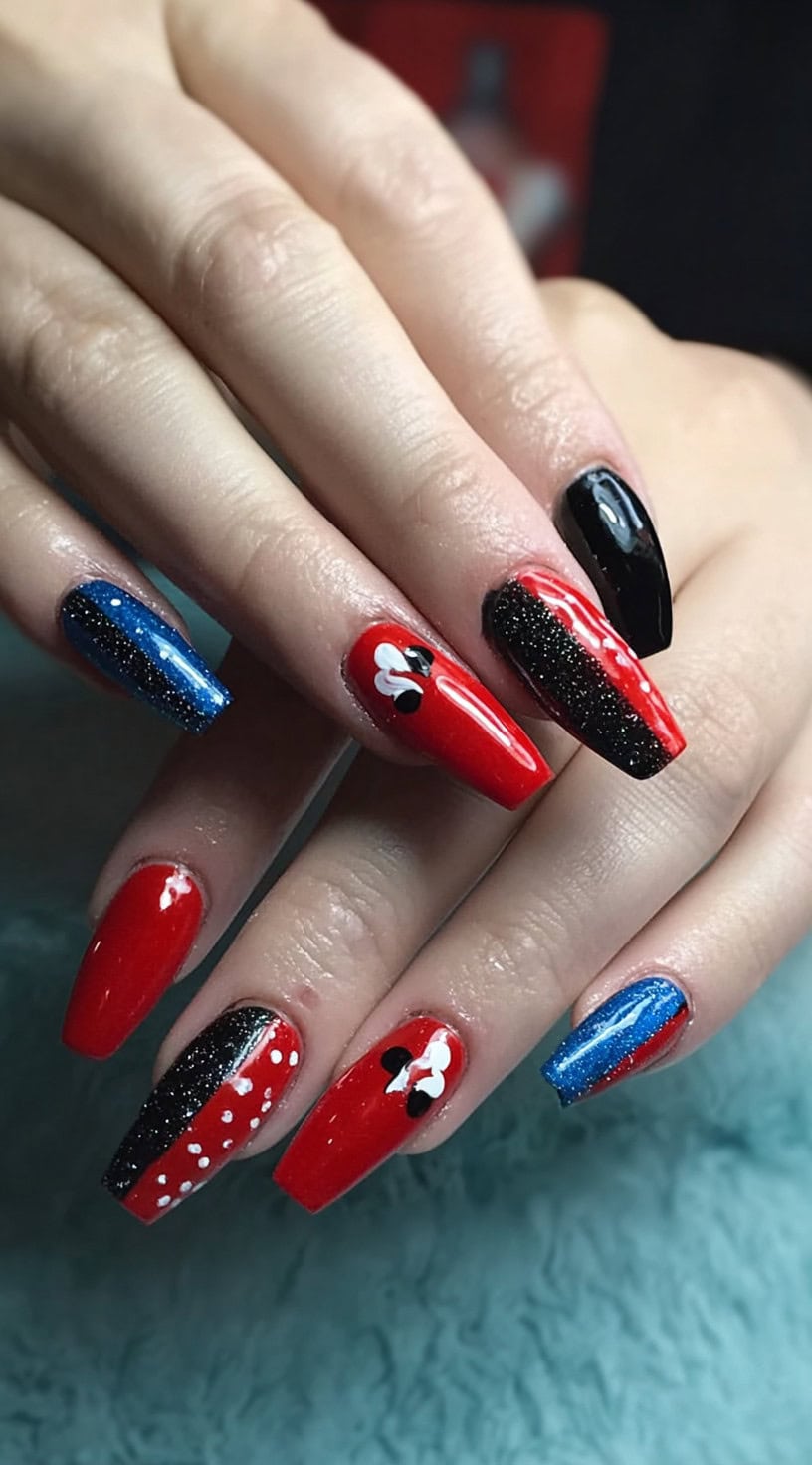 Alternating red, blue, and black coffin-shaped nails with glitter accents and Harley Quinn-style motifs including diamonds and white bows.