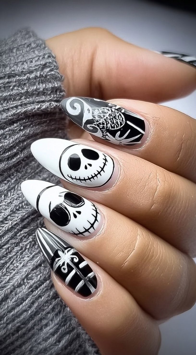 Long almond nails painted in black and white, featuring Jack Skellington faces, stripes, and the iconic spiral hill.