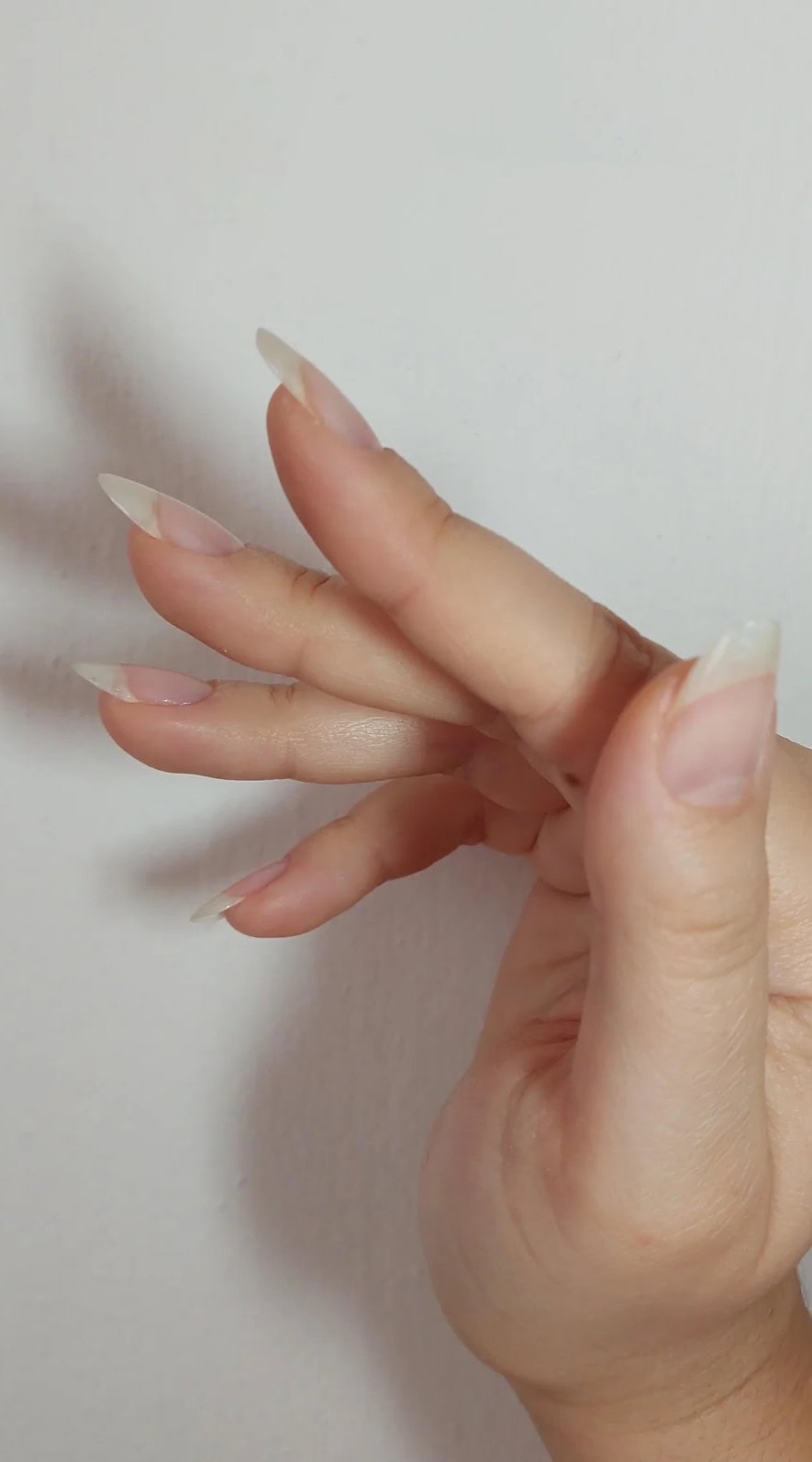 Side view of natural nails showing almond-shaped tips before gel polish application.