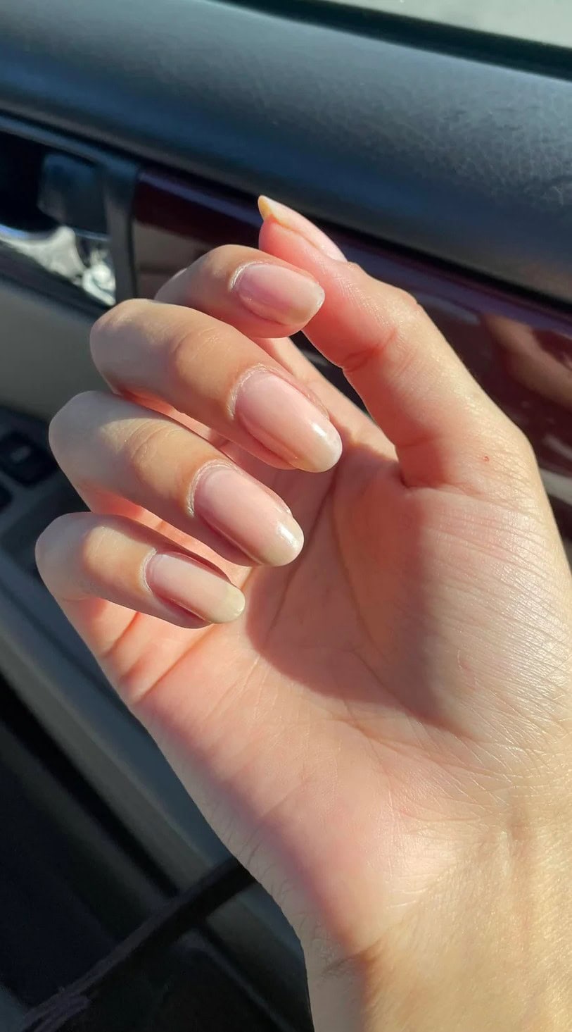 Short round nails with sheer polish, subtly shaped to enhance wide nail beds while keeping a low-maintenance feel.