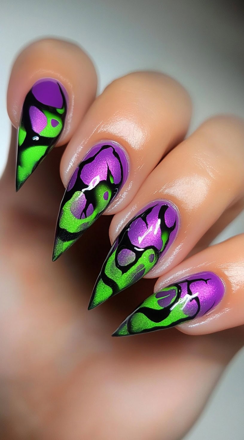 Stiletto nails with neon green and purple flame patterns outlined in bold black against a natural base.