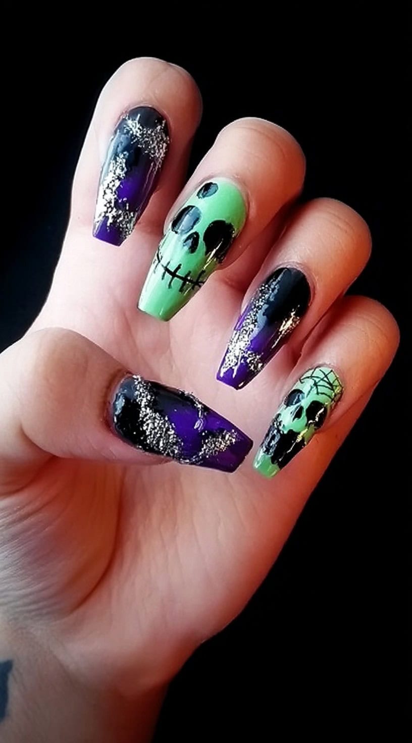 Square-shaped nails with green skull faces, chrome purple backgrounds, and black web detailing with silver glitter.