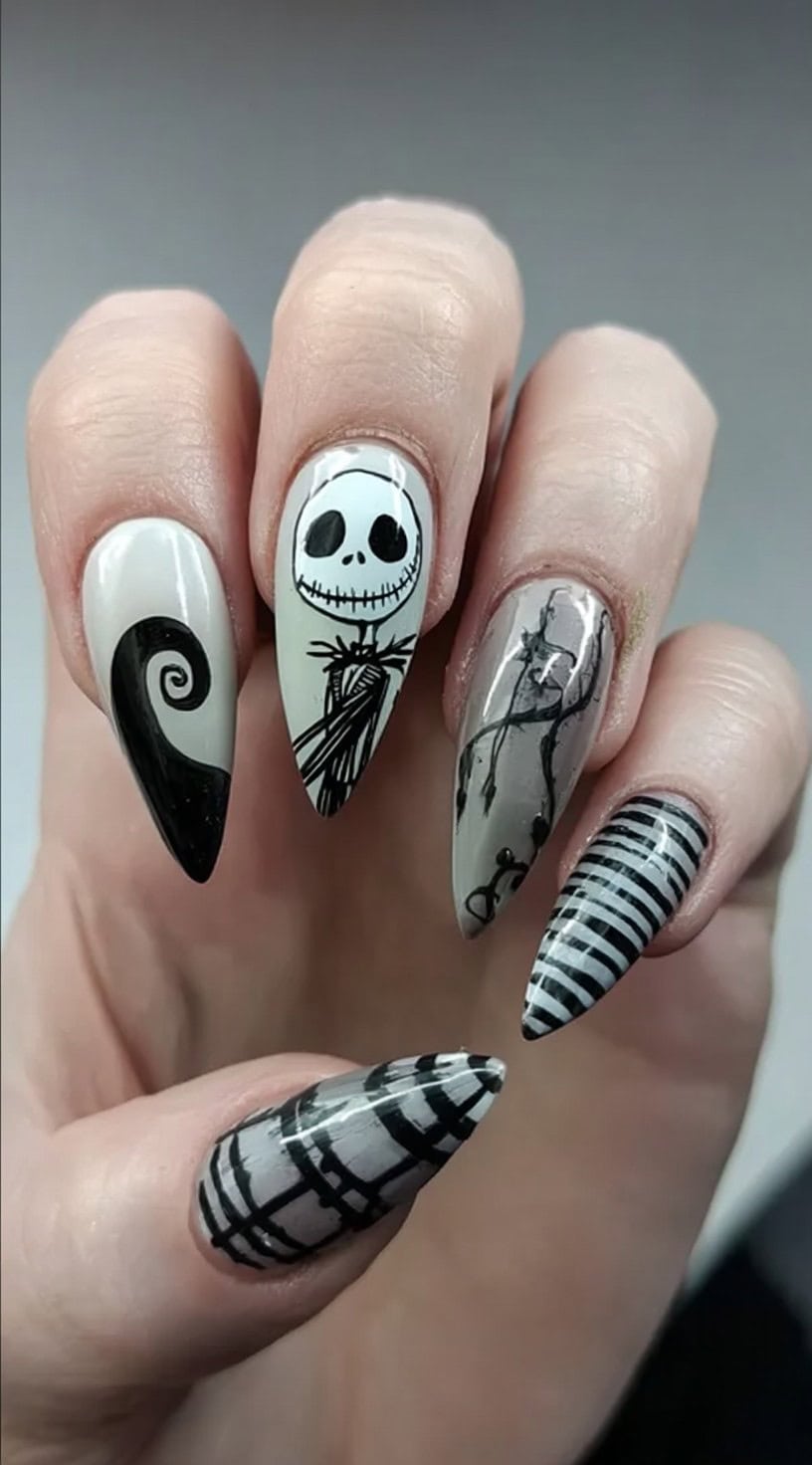 Long almond nails with different designs on each finger, including Jack's face, stripes, swirls, and gothic patterns.