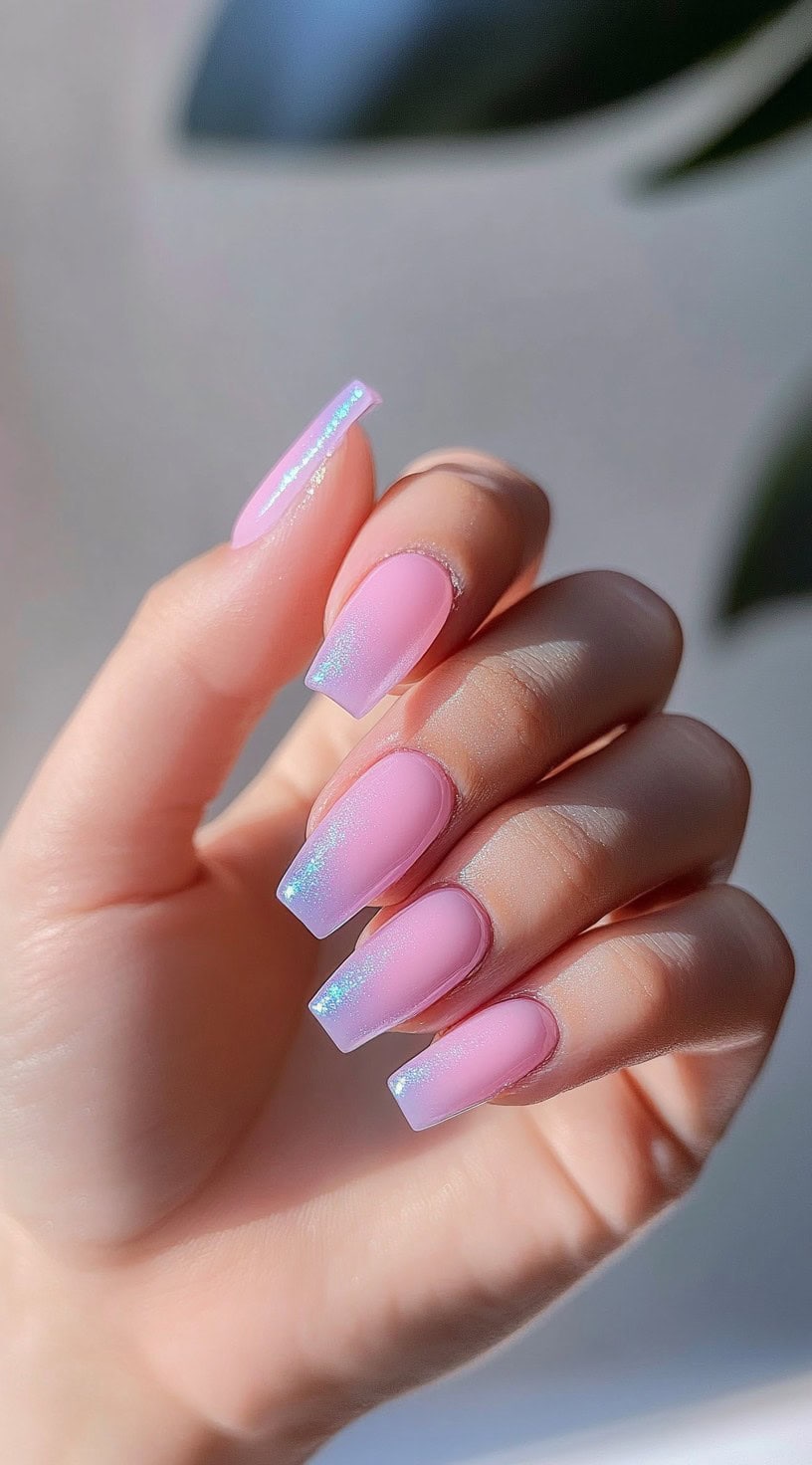 A set of square-shaped nails in a vibrant pink shade with an iridescent chrome finish that reflects light beautifully.