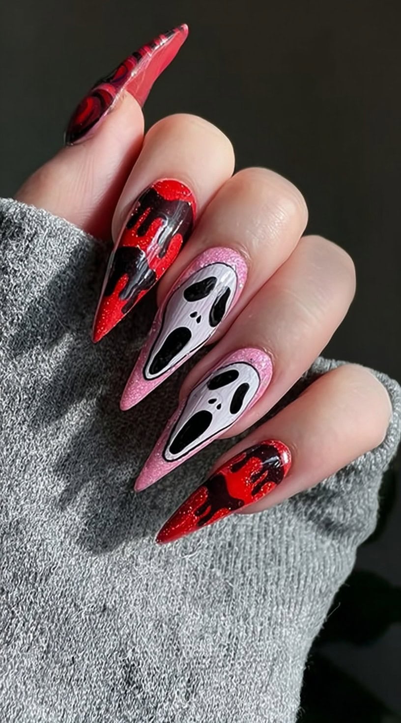 Long stiletto nails with pink glitter bases, Ghostface faces on two nails, and dripping black and red designs on the others.