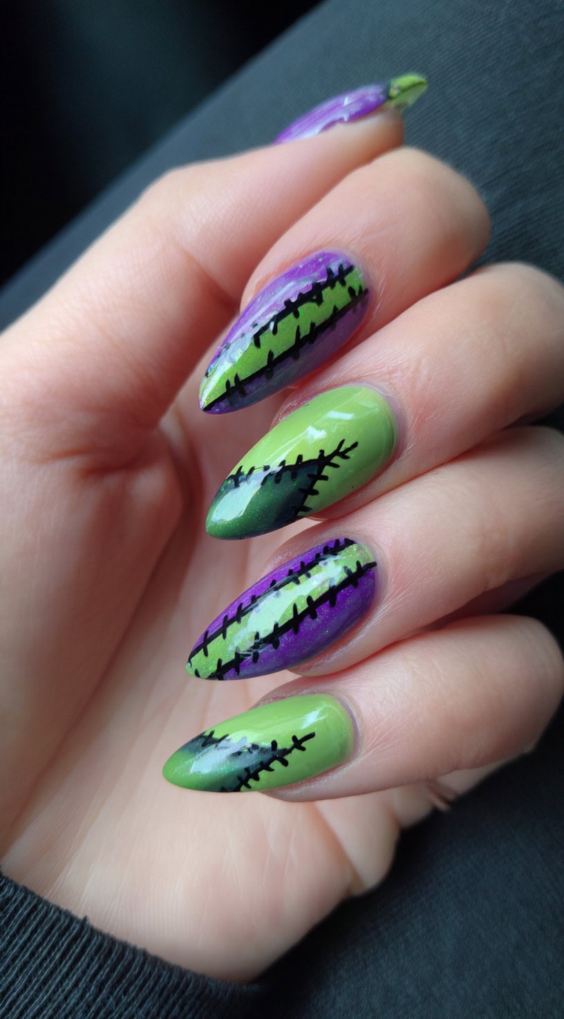 Almond-shaped nails split into green and purple halves with black stitch details down the middle.