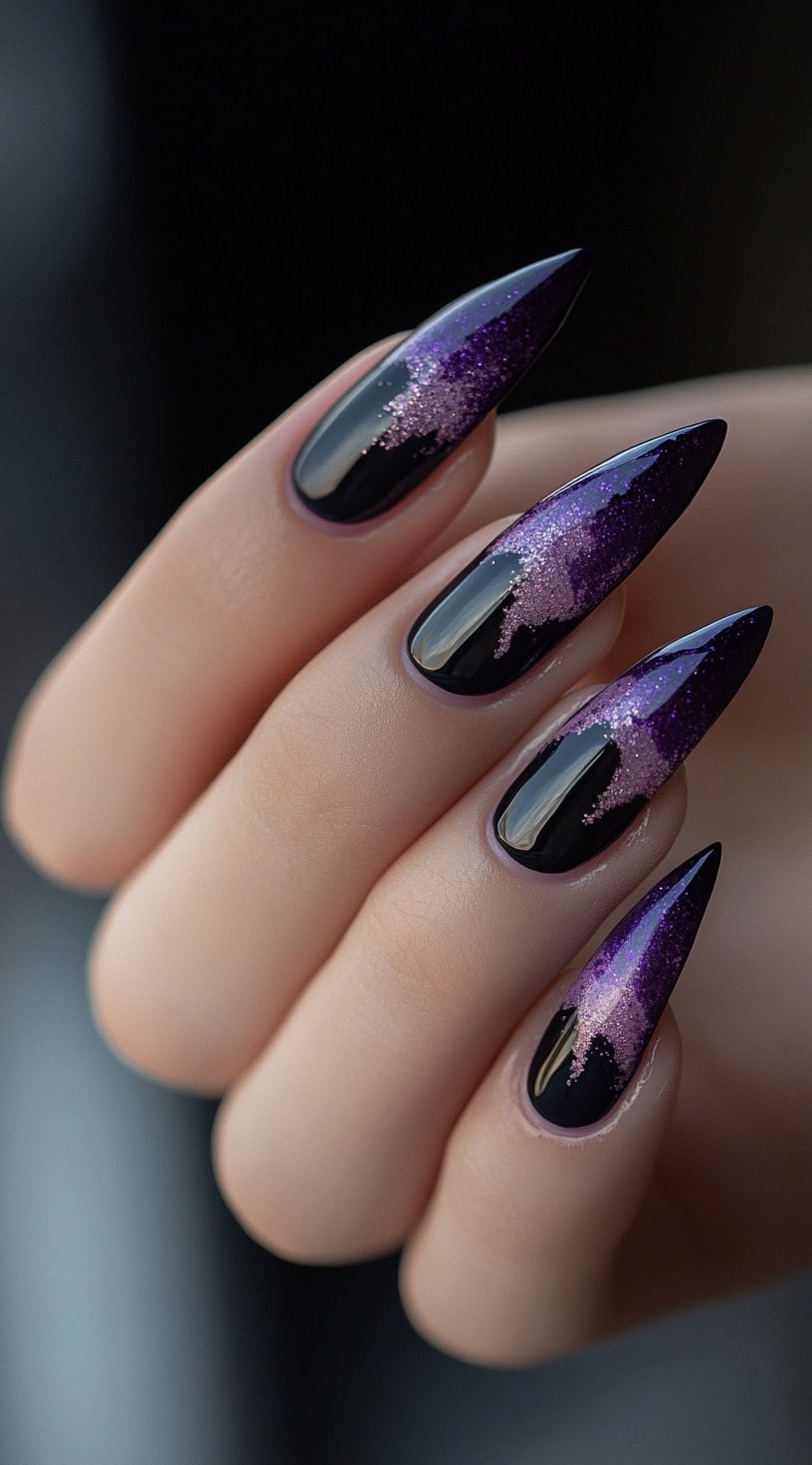 Almond-shaped nails with purple glitter that looks like it's dripping down from the tips over glossy black polish.