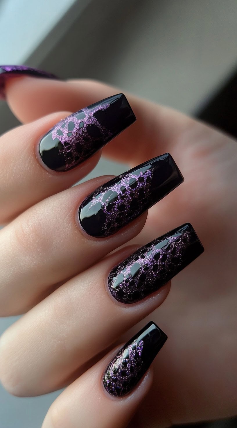 Coffin-shaped nails with a glossy black base and purple glitter lace overlay pattern.