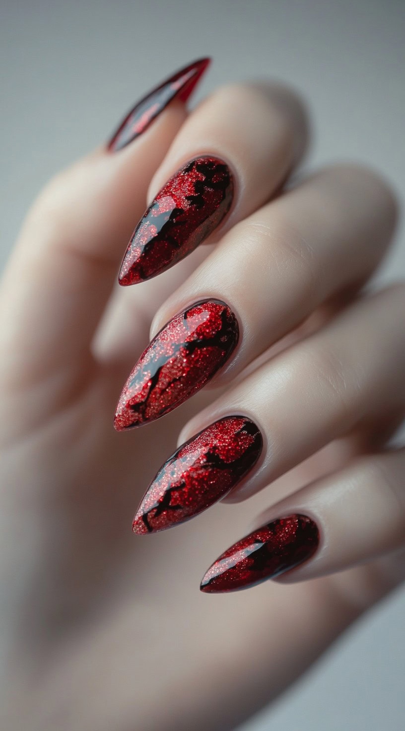 Red stiletto nails with a glittery base and glossy black vein-like patterns resembling molten lava.