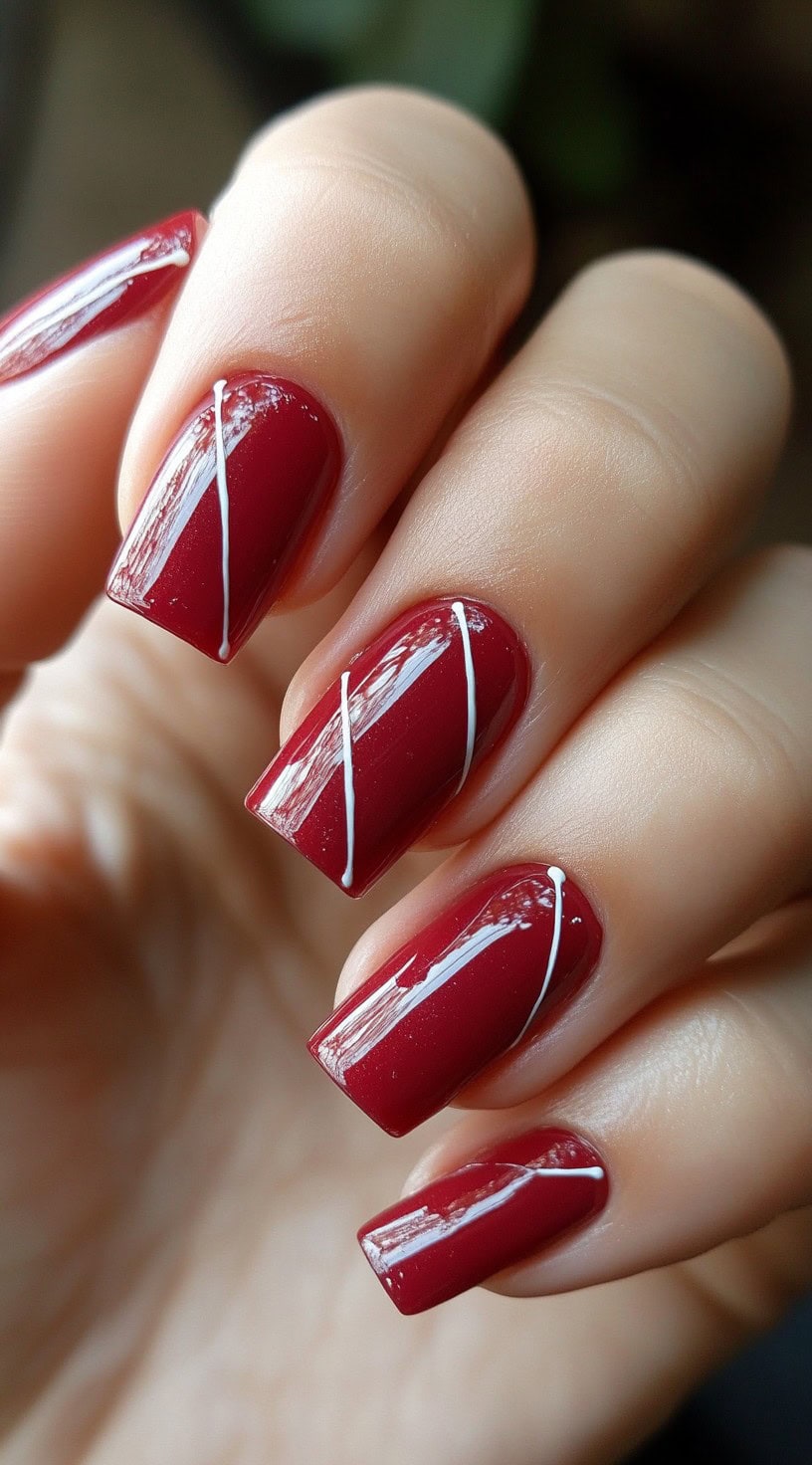 Glossy red square nails featuring fine white diagonal lines across each nail.