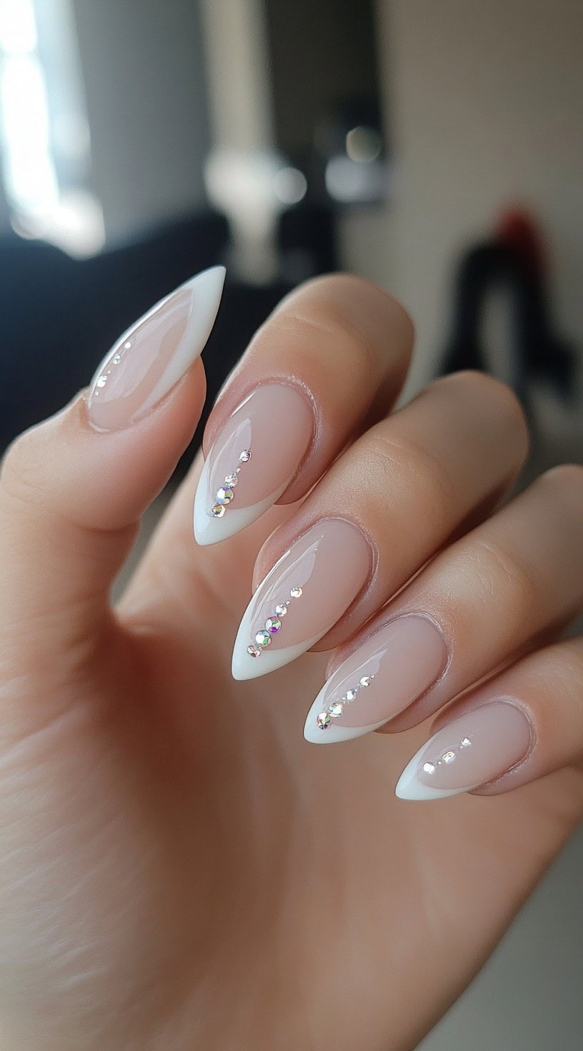 Almond-shaped French nails with rhinestone accents along the center.