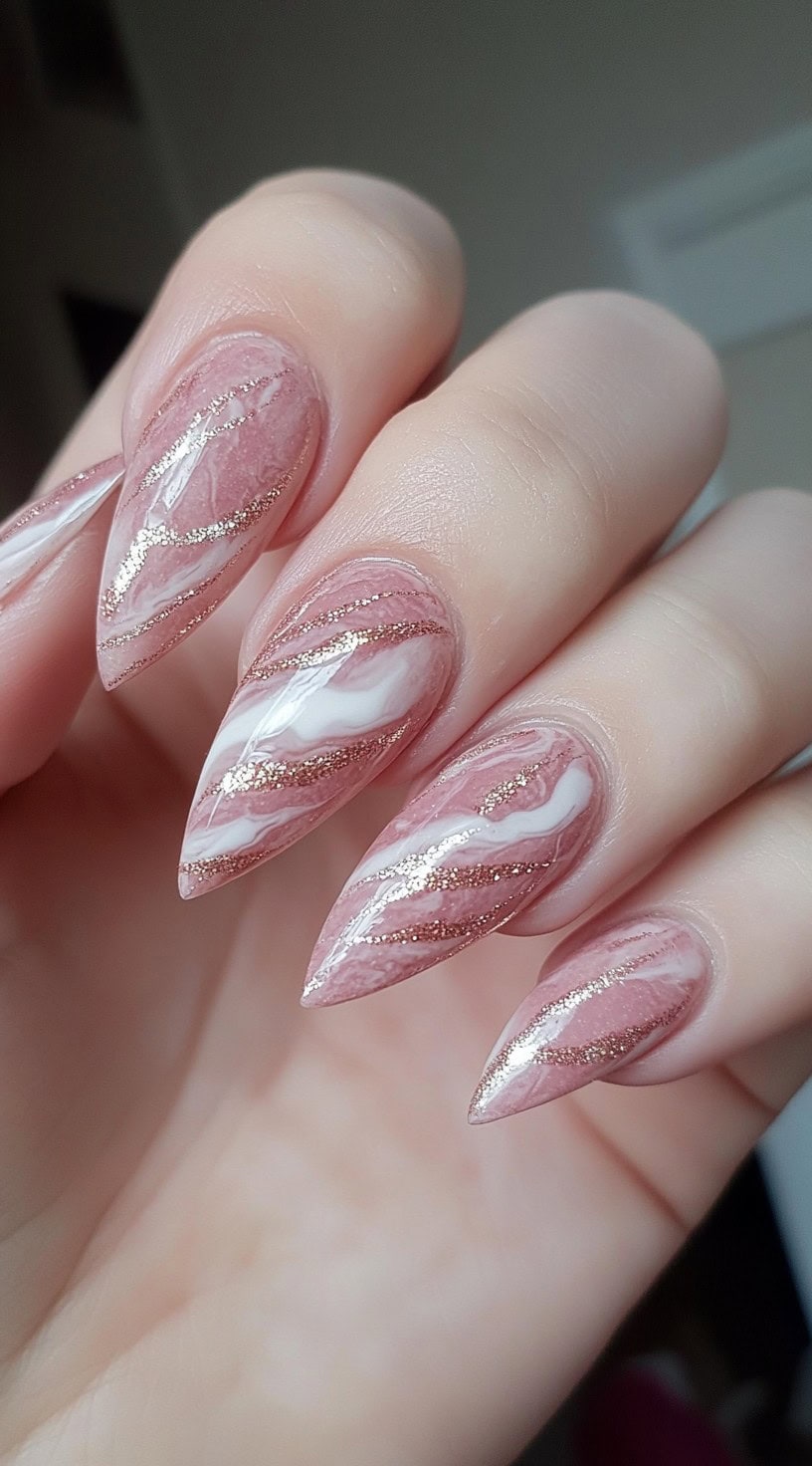 Almond-shaped nails with a soft pink marble effect, featuring delicate white swirls and fine gold veins.