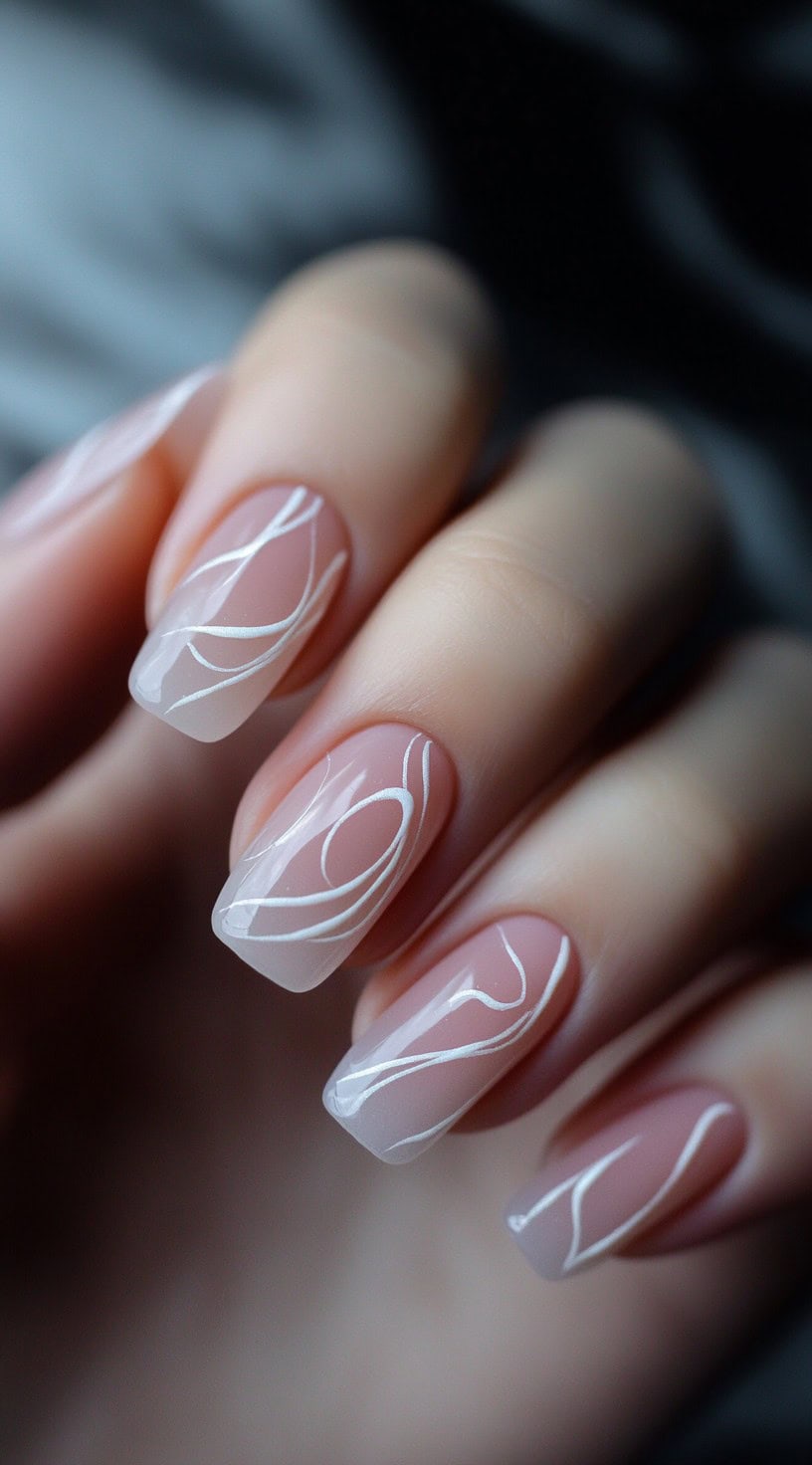 A hand with medium-length square nails featuring a sheer pink base and thin, white flowing lines for a delicate and airy look.