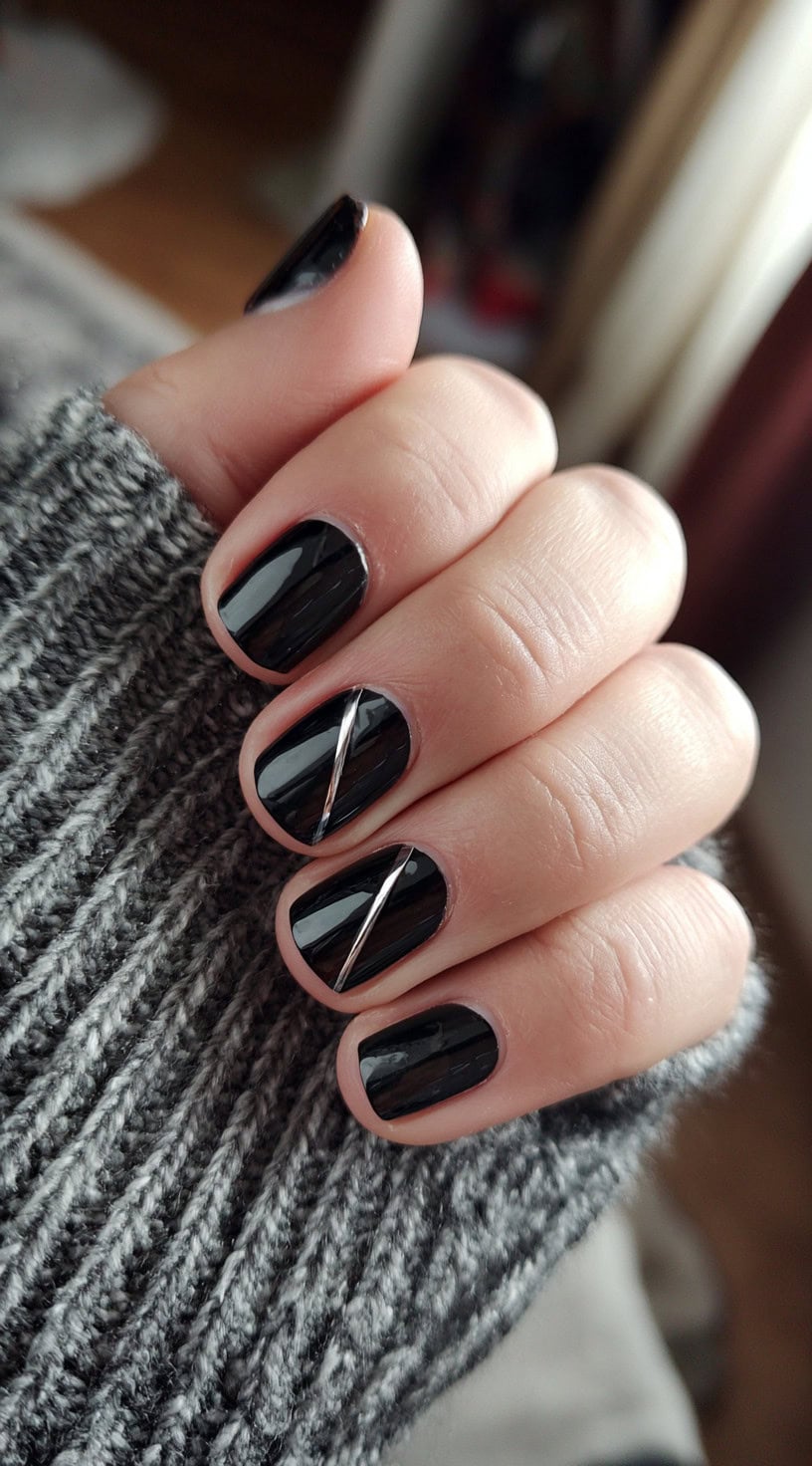 Short glossy black nails with a clean silver diagonal stripe on two accent nails.
